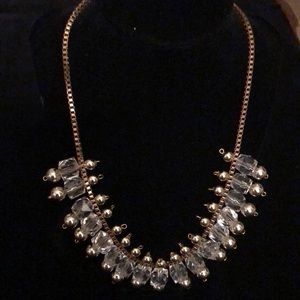 Fashion necklace with clear and light gold beads .